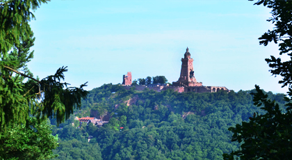 Blick auf eine monumentale Denkmalanlage auf einer bewaldeten Anhöhe