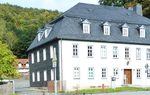 Historisch anmutendes Amtsgebäude mit teilweiser grauer Schieferverkleidung und weißer Frontfassade